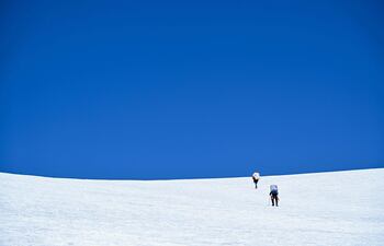Los miembros de la expedición 'Pamir-Ice-Memory', el ruso Ivan Lavrentiev y el tayiko Jahongir Abdullov, ascienden a la base del glaciar de Pamir en Kon Chukurbashi, Tayikistán oriental, el 24 de septiembre de 2025.