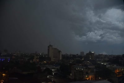 Paisaje urbano de Asunción bajo cielos densamente nublados, edificios iluminados en la parte inferior, sin personas visibles.