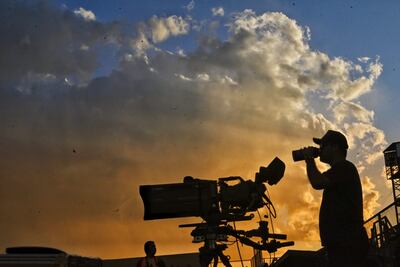Un camarógrafo bebe agua en el atardecer asunceno en el estadio La Huerta de Libertad.