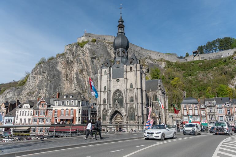 Iglesia de Notre Dame y Ciudadela de Dinant vista desde un puente con tráfico y peatones.