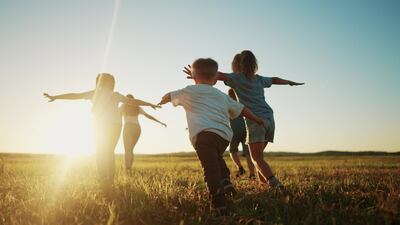 Vacaciones de invierno. Imagen de niños corriendo en un prado.