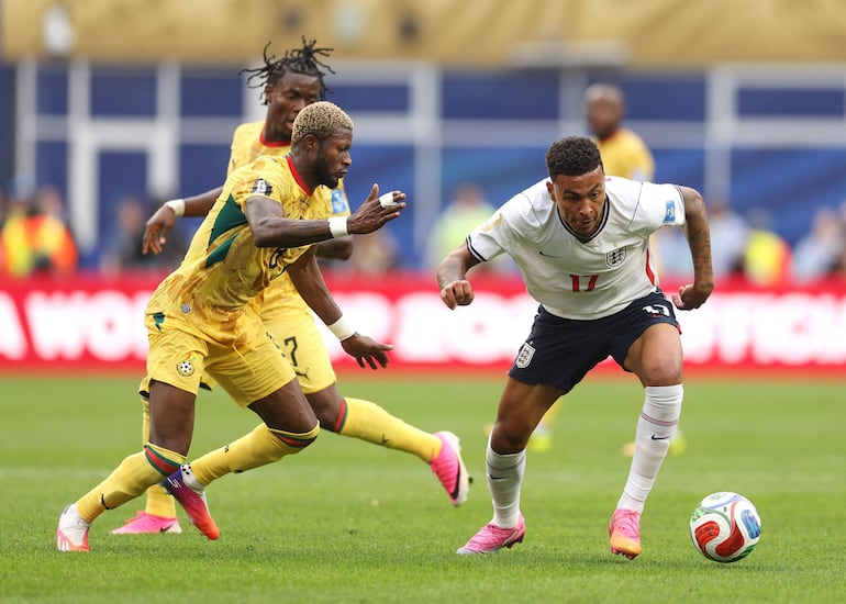 Morgan Rogers (#17) de Inglaterra intenta superar la marca de Kwasi Sibo (#8) de Ghana.