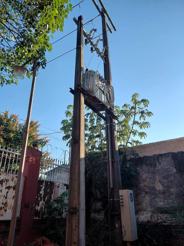 Poste eléctrico con transformadores y cables en un área residencial cerca del Colegio Pablo L. Ávila.