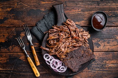 Carne desmechada de Wagyu con salsa barbacoa y cebolla morada.
