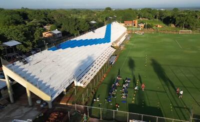Tribuna principal del estadio de Sportivo Ameliano en Villeta, con la V azulada como distintivo.