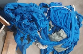 Telas azules desordenadas en un entorno cerrado, sin personas visibles ni objetos identificables.