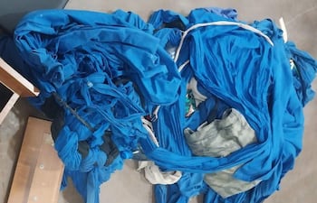 Telas azules desordenadas en un entorno cerrado, sin personas visibles ni objetos identificables.