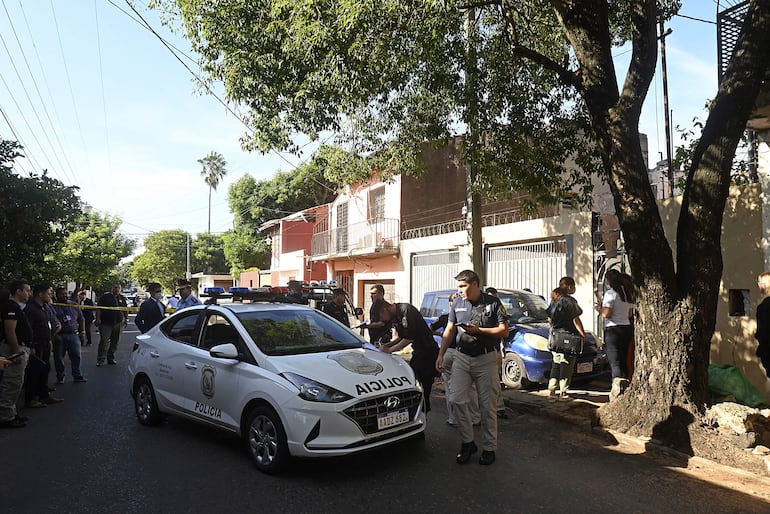 Agentes policiales verifican el vehículo atacado que fue a parar a un costado de la calle.