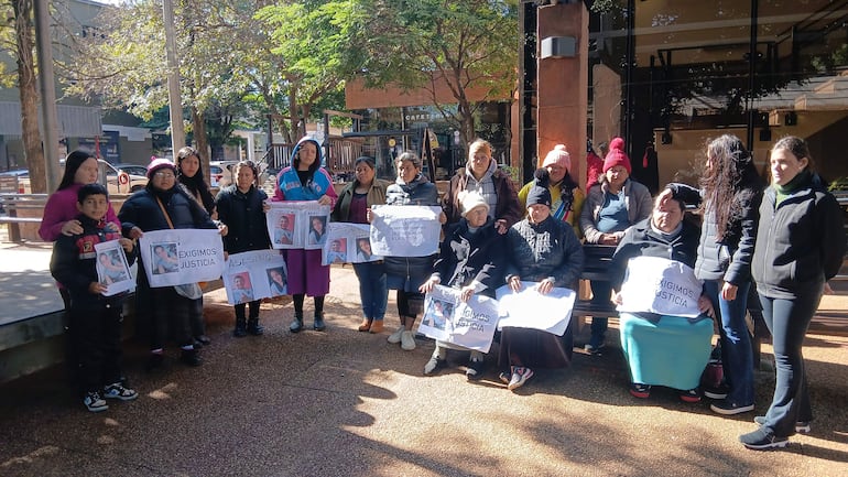 VDB Grupo de manifestantes con carteles exigiendo justicia para Perla Noemí Galeano, en un ambiente fresco y árboles al fondo.