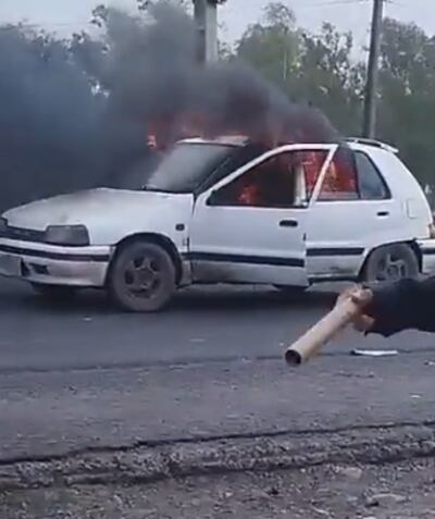 Momento en que auto comenzó a arder en llamas. Hacia la derecha un petardo. (captura de video).
