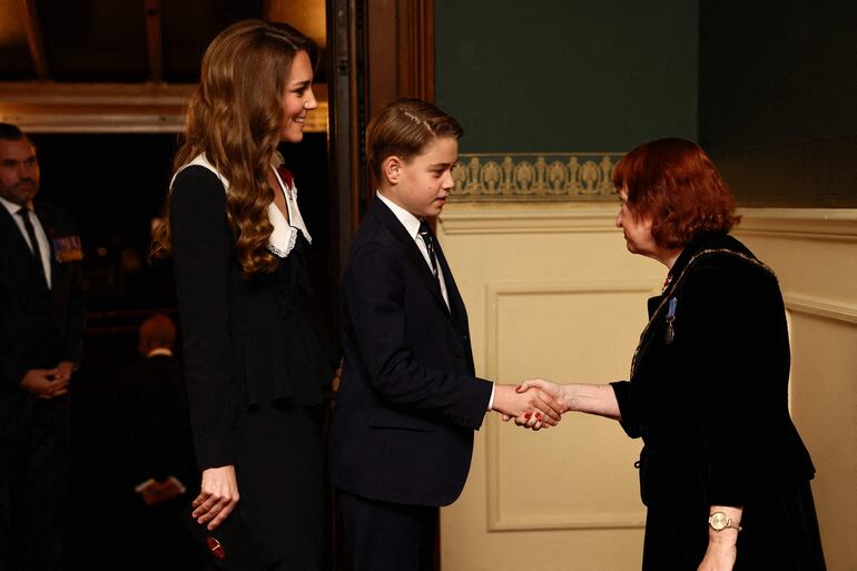 La princesa de Gales y su hijo el príncipe George saludan a una dama al llegar para asistir al Festival del Recuerdo de la Real Legión Británica. (Jack Taylor / POOL / AFP)