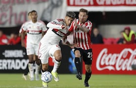 Ezequiel Piovi (d) de Estudiantes disputa el balón con Jorge Carrascal de Flamengo este miércoles, en un partido de la fase de grupos de la Copa Libertadores entre Estudiantes de La Plata y Flamengo en el estadio Jorge Luis Hirschi en La Plata (Argentina).