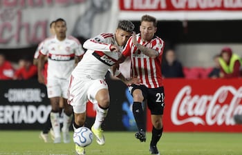 Ezequiel Piovi (d) de Estudiantes disputa el balón con Jorge Carrascal de Flamengo este miércoles, en un partido de la fase de grupos de la Copa Libertadores entre Estudiantes de La Plata y Flamengo en el estadio Jorge Luis Hirschi en La Plata (Argentina).
