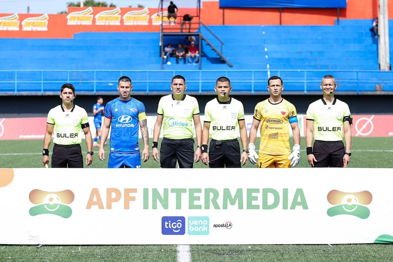 Los protagonistas del juego, capitanes de ambos equipos, juez y asistentes, posan en la previa del encuentro.