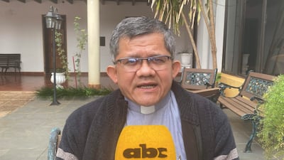 Hombre de mediana edad con gafas y suéter oscuro, sentado con micrófono de ABC Color en un entorno con plantas.