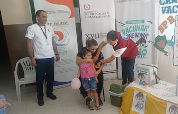 Una pequeña en brazos de su madre, recibe la vacuna en la USF de Fuerte Olimpo.