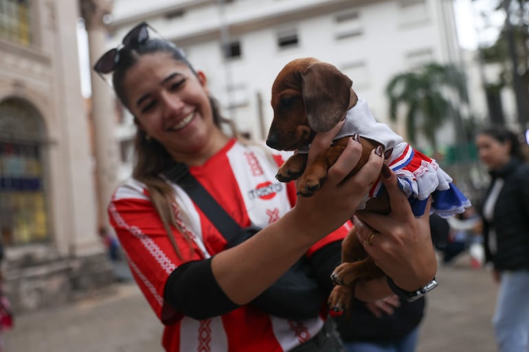 Una mujer sostiene un perro durante el desfile de la celebración del Jagua Patriotaeste jueves, en Asunción.
