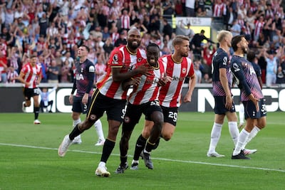 El defensor italiano del Brentford Michael Kayode (C) celebra con el delantero brasileño del Brentford Igor Thiago (I) tras marcar el tercer gol del equipo durante el partido de fútbol de la Premier League inglesa entre el Brentford y el Tottenham Hotspur en el estadio Gtech Community en Londres.