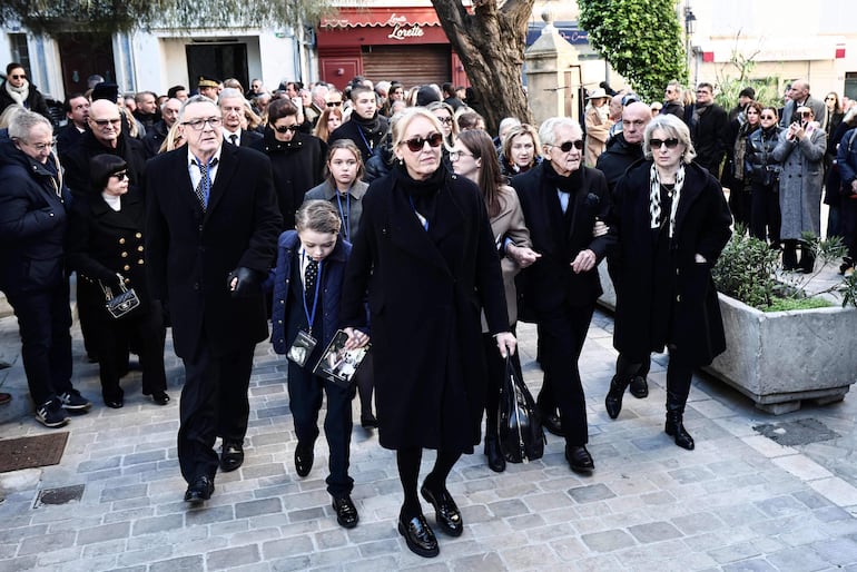 El hijo de Brigitte Bardot, Nicolas-Jacques Charrier (izq.), seguido por la ministra francesa de igualdad, Aurore Berge (atrás en el centro), el esposo de Brigitte Bardot, Bernard D'Ormale (2.º por la der.) y Ghyslaine Calmels-Block (der.), camina en el cortejo fúnebre que transporta el ataúd de su madre hacia el cementerio marino. (Thibaud MORITZ / AFP)