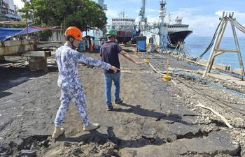 Una fotografía distribuida por la Guardia Costera de Filipinas (PCG) muestra a un trabajador de un astillero (izq.) y a un oficial de la PCG (der.) inspeccionando los daños causados por un terremoto en un astillero de la provincia de Sarangani, en el sur de Filipinas, el 10 de junio de 2026.