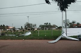 Campo de fútbol en Concepción con láminas de metal dobladas y un ambiente tranquilo rodeado de árboles.
