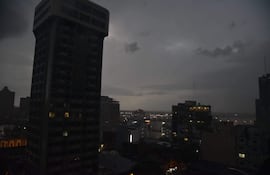 Cielo oscuro y nublado sobre edificios altos en Asunción, creando una atmósfera de tormenta. Sin personas en la imagen.