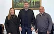 Carmen Giménez de Ovando, Pedro Alliana y Agustín Ovando interactúan en oficina elegantemente decorada con banderas de Paraguay.