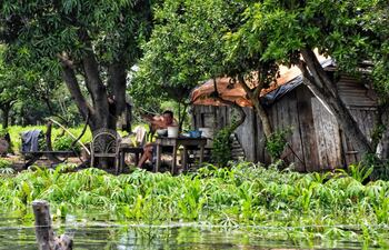 Un poblador de Puerto Carrizal, en Atingy, saluda desde su vivienda totalmente rodeada de agua.