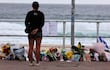 Una mujer se detiene ante ofrendas florales en Bondi Beach para rendir homenaje a las víctimas del tiroteo de Sídney, el 16 de diciembre de 2025.