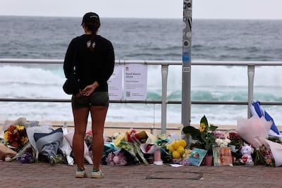 Una mujer se detiene ante ofrendas florales en Bondi Beach para rendir homenaje a las víctimas del tiroteo de Sídney, el 16 de diciembre de 2025.