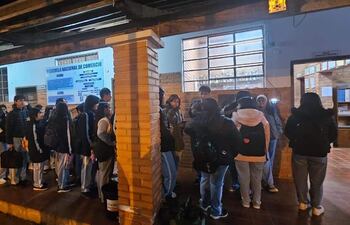 Estudiantes forman una larga fila para marcar su entrada al colegio en Caazapá.