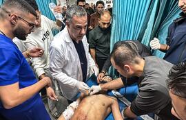 El Dr. Husam Abu Safiya, director del Hospital Kamal Adwan, supervisa la curación de un herido en un bombardeo israelí, noviembre de 2024 (AFP)