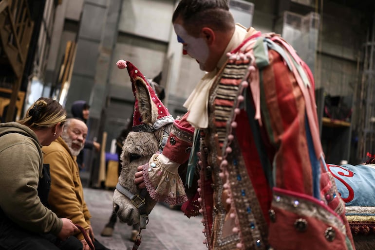 El actor Gregory Warren, quien interpreta a Parpignol, acaricia a Wanda, la burra, mientras esperan entre bambalinas antes de una presentación de La Bohème en el MET Opera de la ciudad de Nueva York, el 6 de diciembre de 2025.