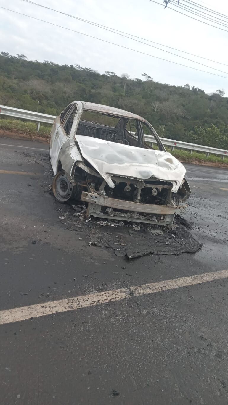 Automóvil Toyota Allion que los criminales abandonaron y quemaron en medio de la ruta.