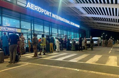 Ciudadanos extranjeros esperan fuera de la terminal del aeropuerto international Diori-Hamani de Niamey, Níger, ayer martes.