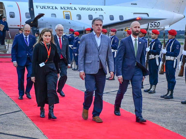 El presidente de Uruguay, Yamandú Orsi (c), junto a la viceministra paraguaya de Relaciones Económicas e Integración, Patricia Frutos (i), durante su llegada al Aeropuerto Internacional Silvio Pettirossi ayer, en Luque (Paraguay). 