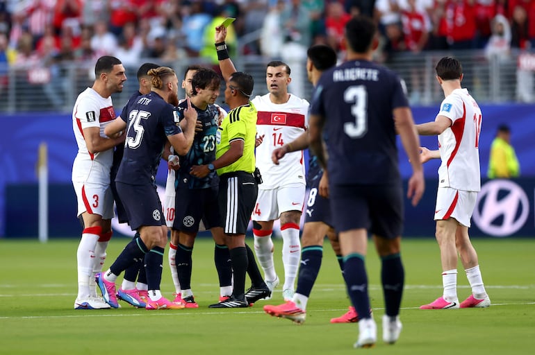 El árbitro Iván Bartón muestra una tarjeta amarilla a Matías Galarza #23 de Paraguay durante el partido del Grupo D de la Copa Mundial de la FIFA 2026 entre Turquía y Paraguay en el San Francisco Bay Area Stadium.