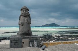 Estatua Dol hareubang en la playa de Geumneung, Isla Jeju, Corea.
