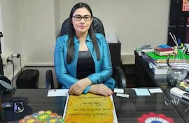 Nélida Alvarenga sentada tras un escritorio, luciendo chaqueta azul y con expresión tranquila en su oficina.