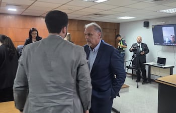 El ex ministro de la SEN Joaquín Roa (de pie) y en el fondo, en pantalla, el condenado Alberto Koube Ayala.
