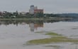 Entorno natural junto a un arroyo, reflejando edificaciones de colores variados en un ambiente tranquilo y deshabitado.