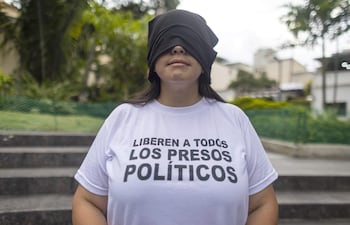 Una persona participa con los ojos vendados en una vigilia para orar por la liberación de los presos políticos en Caracas (Venezuela).