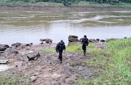Agentes policiales a orillas del río Paraná para el levantamiento de cadáver.