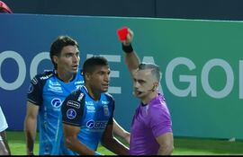 El árbitro paraguayo, Carlos Paul Benítez, le muestra la roja directa, tras exhibirle en dos ocasiones el cartón amarillo al defensor argentino del Blooming de Bolivia, Diago Giménez.