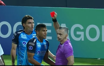 El árbitro paraguayo, Carlos Paul Benítez, le muestra la roja directa, tras exhibirle en dos ocasiones el cartón amarillo al defensor argentino del Blooming de Bolivia, Diago Giménez.