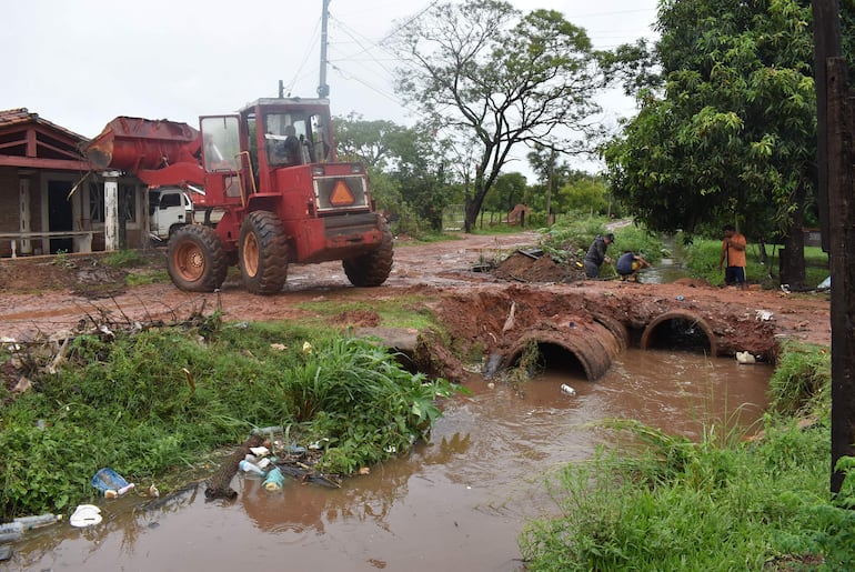 Un grupo de vecinos del barrio Tapiracuai trabajan en la limpieza de una canaleta para evitar que las aguas alcancen sus viviendas 