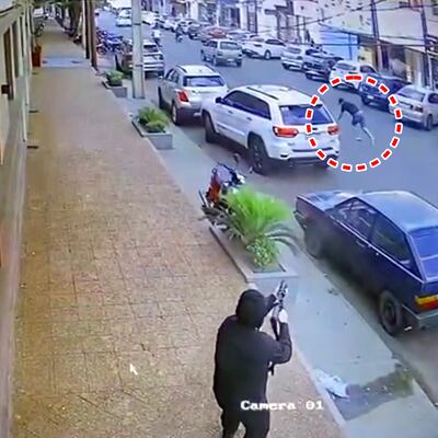 El fusilero de los matones derriba a tiros a su objetivo, Charles González Coronel (en círculo), en plena calle.