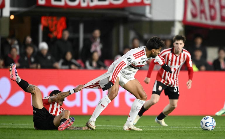 El mediocampista del Flamengo Lucas Paquetá y el mediocampista de Estudiantes Alexis Castro luchan por el balón durante el partido de fútbol de ida de las semifinales de la Copa Libertadores, en el estadio UNO Jorge Luis Hirschi.