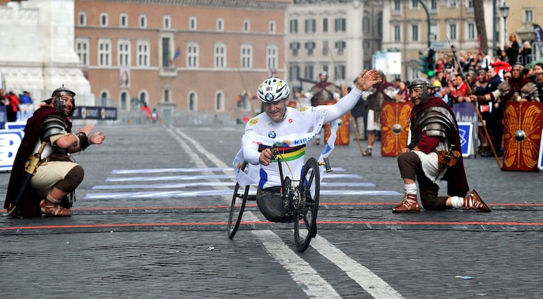 Alex Zanardi celebra al cruzar la meta del Maratón de Roma en 2014. El expiloto y multicampeón paralímpico falleció el 1 de mayo de 2026 a los 59 años. Zanardi es recordado como un símbolo de superación y referente de la inclusión en Italia.