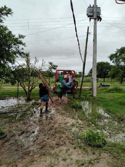 Una familia abandona su vivienda inundada tras el desborde del río Apa , en Bella Vista Norte.
